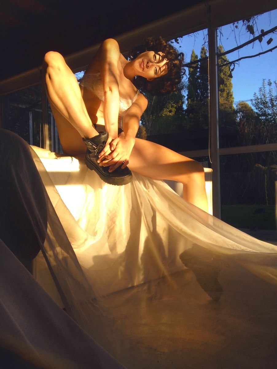 Model in golden light on a sunlit window seat